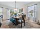 Bright dining area with a table set for six, large windows, and a sliding door to the backyard at 3876 Crossline Dr, Spring Hill, FL 34609
