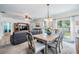 Open-concept living and dining area with a table set for six, a comfortable sofa, and a television at 3876 Crossline Dr, Spring Hill, FL 34609