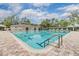 Community pool featuring a lap lane, a building with restrooms, and chairs around the pool at 3876 Crossline Dr, Spring Hill, FL 34609