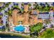 Overhead view of a community clubhouse featuring a pool, putting green, and meticulously maintained grounds at 445 Noble Faire Dr, Sun City Center, FL 33573