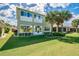 Backyard features a lush lawn, trimmed hedges, and mature palm trees creating a private oasis at 445 Noble Faire Dr, Sun City Center, FL 33573