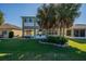 Spacious backyard featuring a well-manicured lawn and beautiful palm trees at 445 Noble Faire Dr, Sun City Center, FL 33573