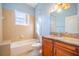 Bathroom with soaking tub, granite vanity, and natural light at 445 Noble Faire Dr, Sun City Center, FL 33573