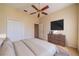 Cozy bedroom featuring a ceiling fan, large closet, dresser with TV, and neutral decor at 445 Noble Faire Dr, Sun City Center, FL 33573