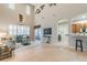 Open-concept living room with large windows, tile flooring, and a view of the kitchen at 445 Noble Faire Dr, Sun City Center, FL 33573