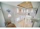 Bright living room overlooking the stairwell with tall windows and modern decor at 445 Noble Faire Dr, Sun City Center, FL 33573