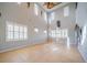 Expansive living room featuring high ceilings, shuttered windows, and neutral tile flooring at 445 Noble Faire Dr, Sun City Center, FL 33573