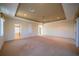 Expansive main bedroom with tray ceiling, fan, and multiple doors at 445 Noble Faire Dr, Sun City Center, FL 33573