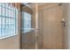 Shower with glass doors and chrome fixtures next to a window featuring horizontal blinds at 445 Noble Faire Dr, Sun City Center, FL 33573