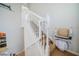 Carpeted staircase with white railing and chair lift, with a partial view of kitchen at 445 Noble Faire Dr, Sun City Center, FL 33573