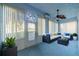 Enclosed sunroom featuring a comfortable seating area, fan, and ample natural light at 445 Noble Faire Dr, Sun City Center, FL 33573