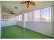 Bright sunroom with green floor, ceiling fans, and large windows at 445 Noble Faire Dr, Sun City Center, FL 33573