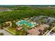 Aerial view of community pool with mature trees, tennis courts, and parking at 4551 Barletta Ct, Wesley Chapel, FL 33543