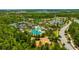 Aerial view of community pool, tennis courts, playground, and surrounding lush greenery at 4551 Barletta Ct, Wesley Chapel, FL 33543