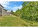 A green backyard with a screened patio is surrounded by bushes and trees at 4551 Barletta Ct, Wesley Chapel, FL 33543