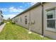 The house has a green lawn alongside the exterior wall, a window, and an external utility meter at 4551 Barletta Ct, Wesley Chapel, FL 33543