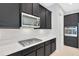 Close-up showcasing a modern kitchen with stainless steel microwave, gas cooktop, and white countertops at 4551 Barletta Ct, Wesley Chapel, FL 33543