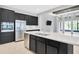 Modern kitchen with stainless steel appliances, black cabinets, and a large island with quartz countertop at 4551 Barletta Ct, Wesley Chapel, FL 33543