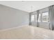 Spacious living room with tile floors, large windows dressed in gray curtains, and contemporary chandelier at 4551 Barletta Ct, Wesley Chapel, FL 33543