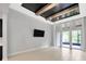 Open floor plan living room with coffered ceiling and access to screened patio at 4551 Barletta Ct, Wesley Chapel, FL 33543
