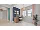 Well-lit office space with built-in desk, shelves, and a stylish chandelier for a productive work environment at 4551 Barletta Ct, Wesley Chapel, FL 33543