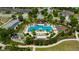 Overhead shot of a community pool, cabanas, palm trees, and manicured hedges at 4551 Barletta Ct, Wesley Chapel, FL 33543