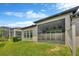 The exterior rear of the house features a screened patio, windows, and a green lawn at 4551 Barletta Ct, Wesley Chapel, FL 33543