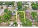 Aerial view of a home site with a yellow box highlighting the property's boundary amidst a lush green landscape at 5042 8Th St, Zephyrhills, FL 33542