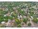 An aerial view of a neighborhood with an arrow pointing to a home surrounded by mature trees at 5042 8Th St, Zephyrhills, FL 33542
