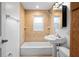 Cozy bathroom features hexagon tile accent wall over tub and pedestal sink at 5042 8Th St, Zephyrhills, FL 33542