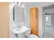 Bright bathroom features a pedestal sink and matching wood linen cabinet at 5042 8Th St, Zephyrhills, FL 33542