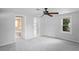 Bright bedroom featuring neutral paint, carpet, ceiling fan, with en-suite bathroom and connecting room at 5042 8Th St, Zephyrhills, FL 33542
