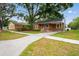 Charming single-story home with a cozy front porch, mature trees, and a well-maintained lawn at 5042 8Th St, Zephyrhills, FL 33542