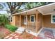 Inviting front porch with wooden railings, steps, and plants creating a warm welcome to the house at 5042 8Th St, Zephyrhills, FL 33542