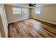 Bright bedroom featuring new wood-look floors, a ceiling fan, and two windows at 6046 7Th Ave, New Port Richey, FL 34653