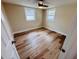 Bedroom featuring wood-look floors, two windows and a modern ceiling fan at 6046 7Th Ave, New Port Richey, FL 34653