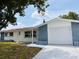 Charming single-story home with a white garage door and gray stone facade at 6046 7Th Ave, New Port Richey, FL 34653