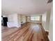 Open-concept living area with wood floors, bright natural light, and a view of the entryway at 6046 7Th Ave, New Port Richey, FL 34653