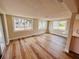 Sunny living room with large windows, hardwood floors, and a view of the updated kitchen at 6046 7Th Ave, New Port Richey, FL 34653