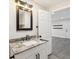 Bathroom vanity featuring granite countertops, modern fixtures, and a decorative mirror at 6436 2Nd S Ave, St Petersburg, FL 33707
