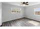 This spacious bedroom has two windows, gray wood floors, and neutral walls at 6436 2Nd S Ave, St Petersburg, FL 33707