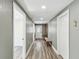 Hallway with bench, coat rack, wood look flooring, and white doors at 6436 2Nd S Ave, St Petersburg, FL 33707