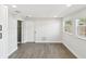 Bright living room with wood-look flooring, white walls, and natural light from the windows at 6436 2Nd S Ave, St Petersburg, FL 33707