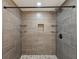 Large tiled shower with a built-in niche, stone pebble floor, and glass shelving at 6436 2Nd S Ave, St Petersburg, FL 33707