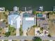 Aerial view of waterfront property with dock, pool, manicured lawn, and lush, tropical landscaping at 743 Kingston Ct, Apollo Beach, FL 33572