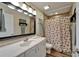 Bathroom with decorative seashell-themed shower curtain, framed mirror, and white vanity at 743 Kingston Ct, Apollo Beach, FL 33572