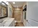 Bathroom featuring a glass shower with detailed tile, a wood-look floor, and a white vanity with marble countertop at 743 Kingston Ct, Apollo Beach, FL 33572