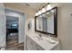 A bright bathroom is displayed with a large black mirror, a white vanity, and a view into a den at 743 Kingston Ct, Apollo Beach, FL 33572