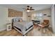 A comfortable bedroom with wood-look flooring, a ceiling fan, a decorative tapestry, and a desk by the window at 743 Kingston Ct, Apollo Beach, FL 33572