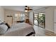 A bright bedroom that offers wood-look flooring, a ceiling fan, large windows with outdoor views, and access to the pool at 743 Kingston Ct, Apollo Beach, FL 33572